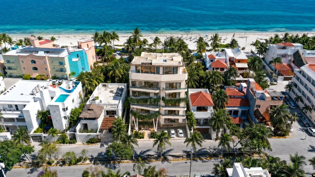 Aerial view of the SENSUM building on Avenida Javier Rojo Gómez, steps from the beach in Puerto Morelos